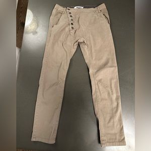 Imperial drop crotch asymmetric button closure.